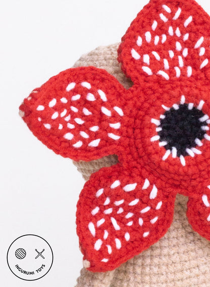 Close-up of the crocheted Demogorgon flower-shaped head with textured red petals and white embroidered details.